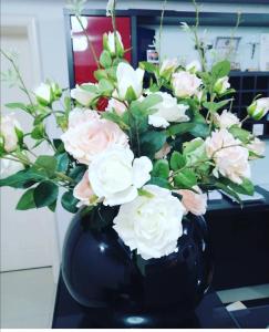 默主歌耶迪娜酒店的黑色花瓶装满粉红色和白色的花