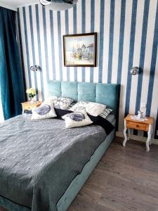 米兹多洛杰Horyzont 411的一间卧室配有一张蓝色和白色条纹的床