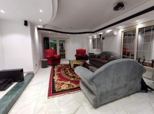 开罗Luxury Apartments的客厅配有灰色的沙发和红色的椅子