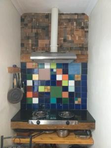 贝蒂湾索尔依松博拉公寓的厨房配有带五颜六色瓷砖墙壁的炉灶。