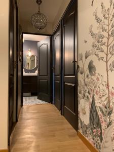 马尼库尔勒翁格尔Luxury Appartement Disneyland的走廊设有黑色门和花卉壁纸