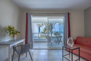 拉斯特拉纳斯考斯塔热纳海滩酒店的客厅配有红色的沙发和桌子