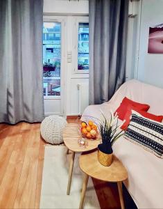 布洛涅-比扬古Cosy Appart Hotel Boulogne -Paris的客厅配有白色的沙发和带水果的桌子。