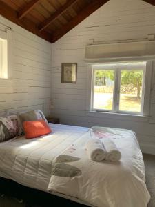  WaipukurauParatu Farm Cottage in a quiet rural setting.的一间卧室配有带毛巾的床