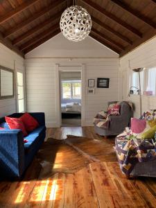  WaipukurauParatu Farm Cottage in a quiet rural setting.的客厅配有两张沙发和一个吊灯。