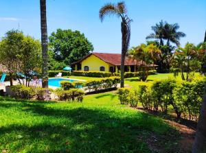 伊比乌纳Casa de Campo Lazer Completo Paraíso de Reservas Naturais em Sp的一个带房子和游泳池的庭院