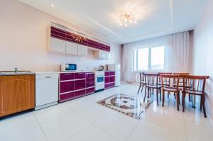 赤塔Dekabrist Apartment at anokhina 93的厨房配有紫色橱柜和桌椅