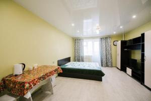 赤塔Dekabrist ul. Serova 30的一间卧室配有绿色的床和电视