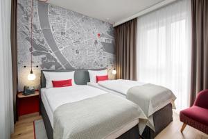 布达佩斯IntercityHotel Budapest的两张位于酒店客房的床,墙上有地图