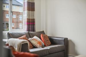 斯坦维尔London Heathrow Living Holywell Serviced Houses - 3 and 4 bedrooms By Ferndale的客厅配有带枕头的沙发。