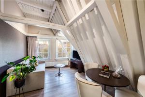 阿姆斯特丹NH精选巴比松皇宫公寓的客厅配有桌椅