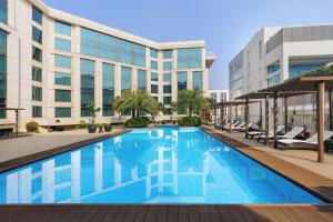 新德里新德里空港骄傲广场酒店的大楼前的游泳池