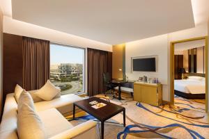 新德里新德里空港骄傲广场酒店的酒店客房设有一张沙发和一张床
