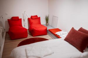 萨利色尔卡Luttokolo, Saariselkä的卧室配有红色枕头、一张床和一张沙发