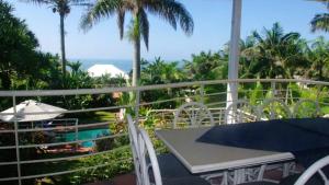 斯坦格Thoko-Zani Beach House的度假村阳台上的桌椅