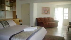 斯坦格Thoko-Zani Beach House的一间卧室配有一张大床和一张沙发