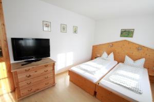 锡格马林根普非菲尔勒度假公寓式酒店的一间卧室配有两张床和一台平面电视