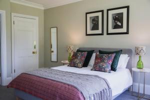 瓦伊河畔罗斯Bridstow Guest House的卧室配有一张带两张桌子的床,墙上有两张照片