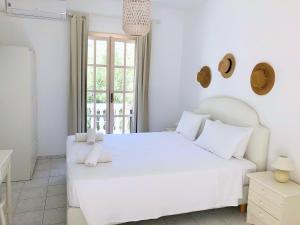 Ambrami佩特里诺酒店的白色的卧室设有白色的床和窗户。