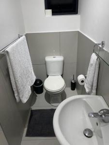 乔治Miles House的浴室配有白色卫生间和盥洗盆。