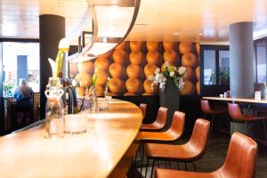 霍夫多普阿姆斯特丹机场贝斯韦斯特优质酒店的餐厅设有长桌子、椅子和鲜花