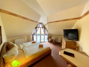 格罗斯吉恩滕豪斯贝尔格酒店的一间卧室配有一张床,并在一间客房内配有电视。