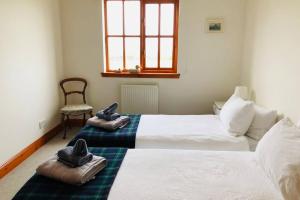 圣安德鲁斯Home with superb view of St Andrews的一间卧室配有两张床和拖鞋。