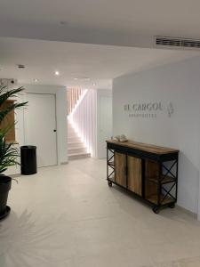 莱斯卡拉Aparthotel El Cargol的一间白色的房间,中间设有一张桌子