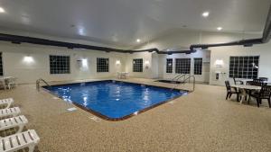 Estherville埃斯特维尔套房酒店的一个带桌椅的房间的大型游泳池