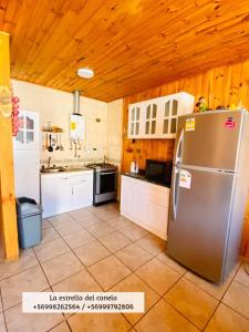 阿尔加罗沃La Estrella del canelo的厨房设有不锈钢冰箱和木制天花板。