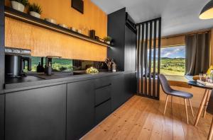 新巴尼亚Kutica的厨房配有黑色橱柜和桌椅