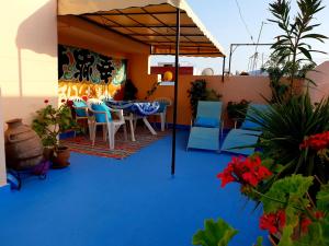 艾西拉Dar Khadija的蓝色地板上带桌椅的庭院