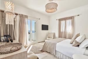 PaliochoriVolcano Luxury Suites Milos - Adults Only的白色卧室配有床和沙发