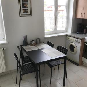 施托克劳LG living Apartment的厨房配有桌椅和洗衣机。