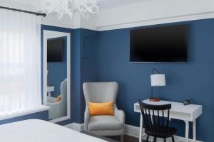 纽约voco The Franklin New York, an IHG Hotel的一间卧室设有蓝色的墙壁、椅子和书桌