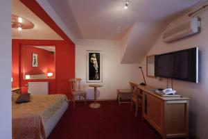 奥西耶克千年酒店的配有一张床和一台平面电视的酒店客房