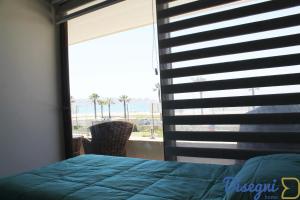 科金博Departamento Av del Mar Coquimbo Disegni 03的一间卧室设有窗户,享有海滩美景