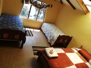 Comunidad YumaniHostal Palacio del Inca的一间卧室设有两张床和窗户。
