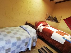 Comunidad YumaniHostal Palacio del Inca的黄色墙壁客房的两张床