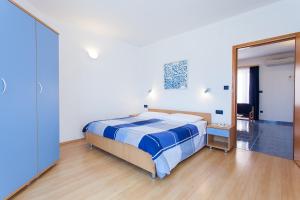 法扎纳Apartments Villa Brioni II的一间卧室配有一张床和一面大镜子