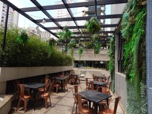 圣保罗圣保罗莫埃马美居酒店的户外庭院设有桌椅和植物