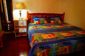 迪坡斯特兰霍斯佩达耶拉霍加旅馆的一间卧室配有一张带五颜六色棉被的床