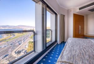 伊兹密尔科纳克贝斯特韦斯特酒店的卧室设有大窗户,享有高速公路的景色