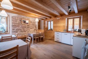 RotzoCasa Ekharle - Affittacamere的一间厨房和用餐室,配有木墙和木地板