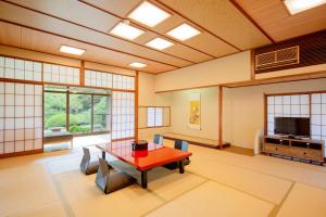 北九州Suisui Garden Ryokan (in the Art Hotel Kokura New Tagawa)的一间设有桌子和电视的房间