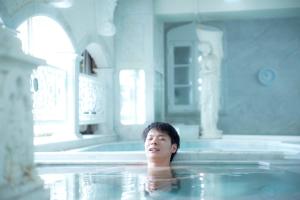 东京新宿区役所前胶囊酒店的男人在浴缸里游泳
