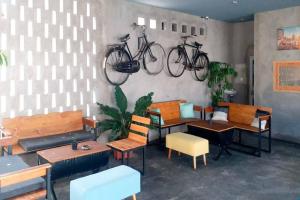 马塔兰RedDoorz Syariah near Lombok Epicentrum Mall的一间设有桌椅的房间和挂在墙上的自行车