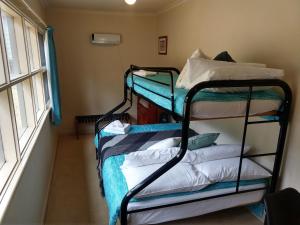霍尔斯加普Cockatoo Cabin的带窗户的客房内的两张双层床