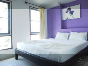 皮皮岛皮皮岛象牙酒店的一间卧室设有紫色的墙壁和一张大床