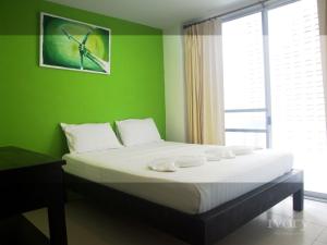 皮皮岛皮皮岛象牙酒店的一间卧室配有一张带绿色墙壁的床